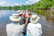 Tourist group arriving at Amazon rainforest lodge by canoe, Yasuni national park, Amazon river basin, Ecuador.