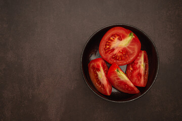 Wall Mural - Tov view of fresh tomatoes in a black bowl on a table