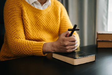 Wall Mural - Hands together in prayer to God along with the bible In the Christian concept and religion, woman pray in the Bible on the wooden table