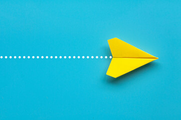 Wall Mural - Top view of yellow paper airplane on blue background