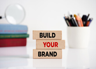 Branding or brand building in business and marketing. The message build your brand on wooden blocks.