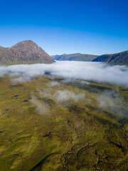 Wall Mural - Aerial view of low cloud and fog in a valley just after dawn (Glencoe, Scottish Highlands)
