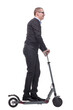 © ASDF - Side view of happy man rides a black kick scooter