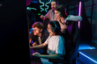 © Drobot Dean - Group of people watching their friend playing video game and assisting her in cybersport club