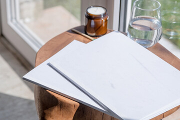 Magazine and book mockup design. Blank magazine on modern wooden table with candles , shadow overlay