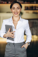 Canvas Print - Business woman holding tablet in a cafe