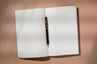 © Tetra Images - Pen in open notebook on brown background