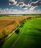 Fototapeta Kwiaty - Warmia and Mazury - spring agricultural landscape Linowo near Olsztyn. Lake Linowskie in the distance