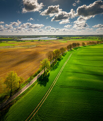 warmia and mazury - spring agricultural landscape linowo near olsztyn. lake linowskie in the distanc