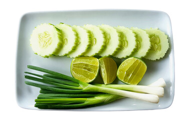 Wall Mural - Top view of fresh spring onion, sliced cucumber and lime or lemon in white plate isolated on transparent background with clipping path and transparency. Flat lay of organic vegetable food on dish.