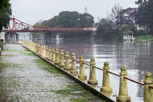 Pedestrian Walk Along The River, With The Carmelo Bridge In The Background, During A Rainy Day