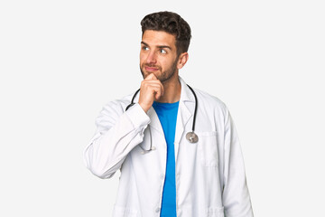 Young doctor man looking sideways with doubtful and skeptical expression.