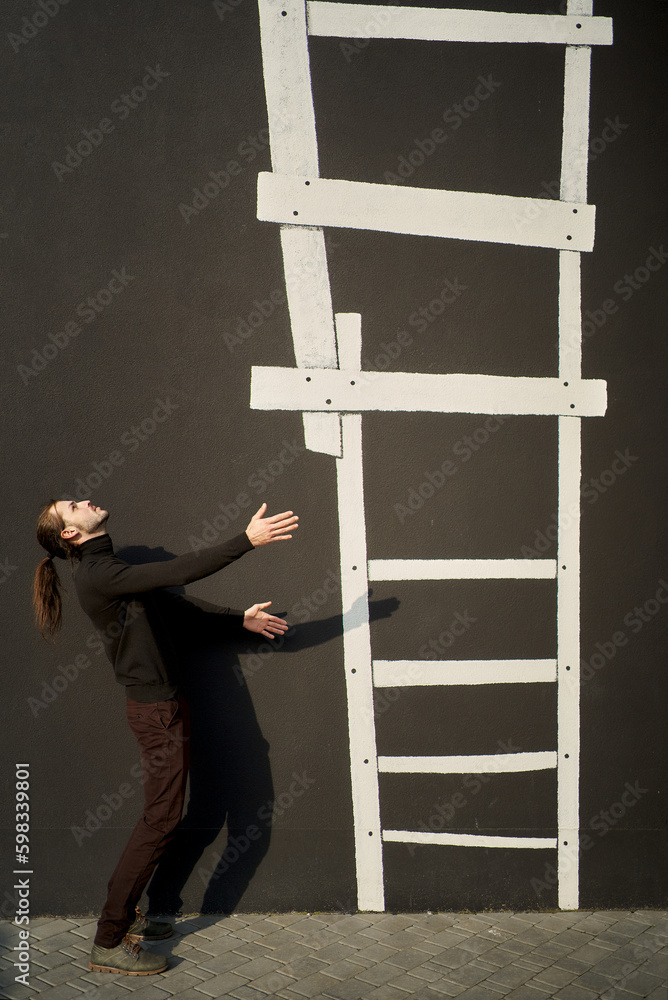 Man in black wear standing sideways with his arms stretched out to illustrated staircase going upwards. The ladder is a visual representation of the social hierarchy. Ascending to Social Ladder