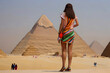 A female tourist in the desert against the background of the Egyptian pyramids. Travel to Egypt. Generative AI.