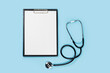 © eliosdnepr - Blank medical clipboard with stethoscope on blue background concept. Copy space.