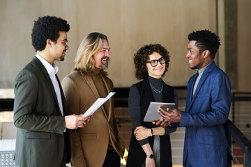 Poster - Group of happy brokers listening to young African American colleague with tablet making presentation of stock market fluctuations
