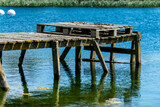 Fototapeta Pomosty - Old wooden jetty on blue water