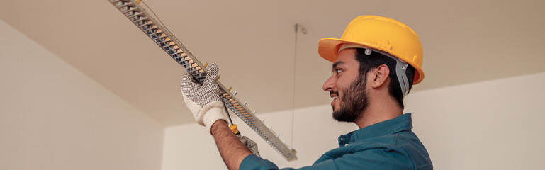 electrician worker is installing electric lamps light in kitchen. construction decoration concept