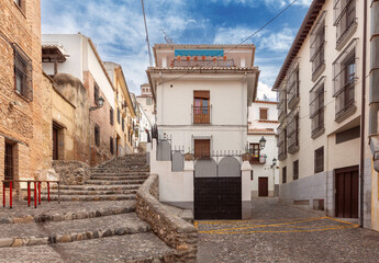 Wall Mural - Granada. Old traditional narrow city street with white houses.