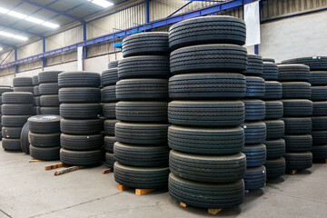 View of assorted new automotive road tires or tyres, showing a variety of tread patterns. It is a ring-shaped component that surrounds a wheel's rim to transfer a vehicle's load.