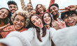 © Davide Angelini - International group of young people laughing at camera outside - Happy friends taking selfie pic with smartphone device - Life style concept with guys and girls hanging out together