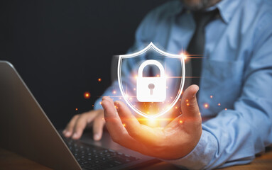 The technology of security for protect private data of personal. Technology, business, and innovation concept. Businessman holding a lock with a shield on hand to safeguard violation of privacy.