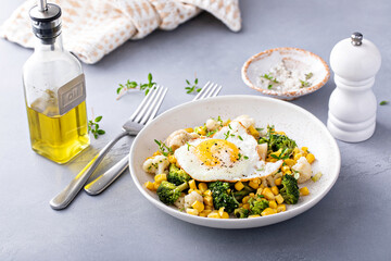 Wall Mural - Healthy breakfast bowl with cooked vegetables and fried egg