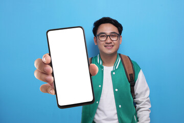 Asian man looking to camera, smiling and showing empty blank white copy space phone mock up template
