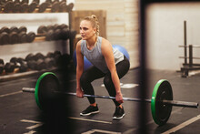 Fit Young Woman Lifting Heavy Weights In A Gym