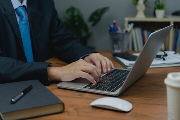 Wall Mural - man sitting at a desk, typing on a laptop keyboard computer. of online connectivity and job search in our personal. as technology, social media, online marketing, and education.