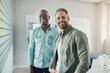 © Flamingo Images - Diverse businessmen smiling while brainstorming with adhesive notes in an office