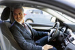 © Westend61 - Smiling businessman sitting on driver's seat in car