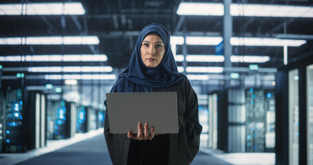 Poster - Portrait of a Young Middle Eastern Female IT System Engineer Wearing Traditional Hijab, Using Laptop Computer in a Modern Technological Server Facility. Arab Artificial Intelligence Expert at Work