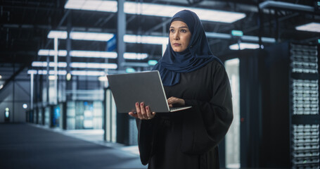 Poster - Muslim Female Data Center IT Engineer Standing in a Room with Server Racks. Cloud Computing Architect Uses Laptop Computer for Servicing the System in Cyber Security and Data Protection Facility