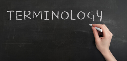 Wall Mural - A woman's hand write text Terminology with chalk on chalkboard