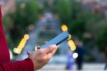 Wall Mural - On the background of the city, a man holds a phone