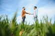 © Serhii - Indian and European farmers stand in a field of green wheat