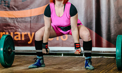 Wall Mural - woman powerlifter performing deadlift in powerlifting competition, power sports games