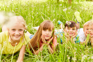 Wall Mural - Children lying down in meadow during vacation