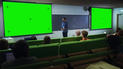 Poster - Young University Professor Giving a Lecture, Pointing on a Green Screen Mock Up Display. Group of Talented Diverse Students Study in Modern Classroom. Teacher Showing Content on Two Big Screens