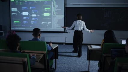 Leinwandbilder - Young Teacher Giving a Web Development Presentation to a Diverse Multiethnic Group of Female and Male Students in a Modern College Room. Female Walking Between the Rows While Giving a Lecture