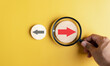 © Kiattisak - Hand holding magnifier focus to Red arrow and different direction facing opposite direction with black arrow for business disruption and technology transformation and different thinking idea concept.