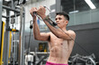 © FotoArtist - Young active athlete exercising on cross training equipment in fitness center or gym