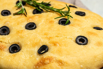 Wall Mural - Close up Italian Focaccia with black olives and rosemary. Food recipe background