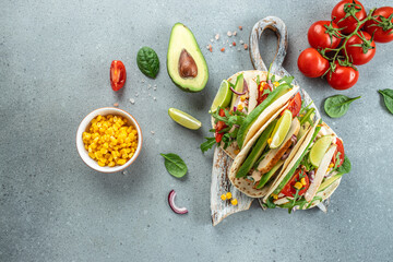 Healthy corn tortillas with grilled chicken, avocado, fresh tomatoes, limes. Mexican dish. place for text, top view