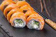 Sushi roll philadelphia with salmon and cucumber and cream cheese on black background. Sushi menu. Japanese food concept