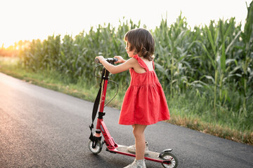 Wall Mural - girl in red dress riding red scooter