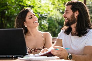 pretty college student talking to colleague in table outside