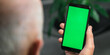 © Bonsales - Male doctor holding in hands cell phone app mock up with green screen over shoulder view. Healthcare and telemedicine online consultation concept. Remote mobile medical application for smartphone.