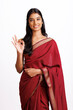 Cheerful Indian woman in traditional saree showing ok sign isolated on white.